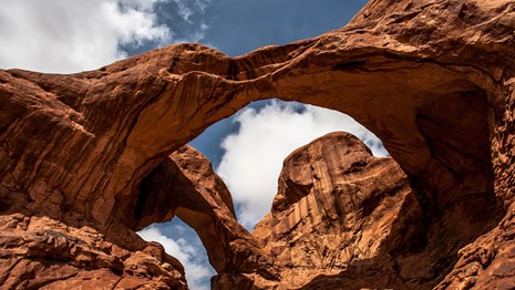 a large, double arch with clouds overhead