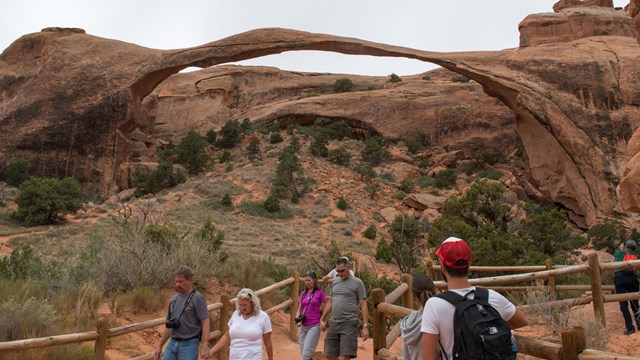 a group of people view a broad, thin arch