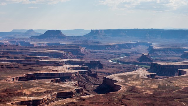 a broad view of canyons with a river at the bottom