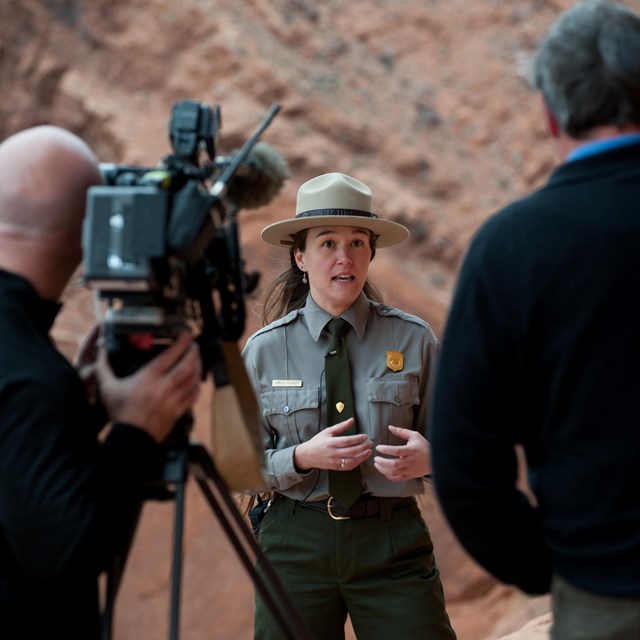 a ranger stands with a camera crew