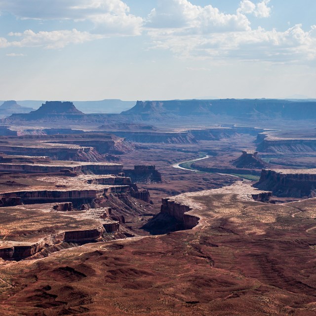 a broad view of canyons with a river at the bottom