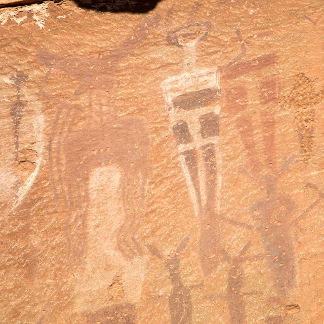 human shaped figures painted onto a rock wall