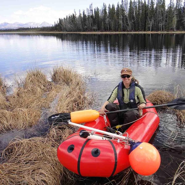 A researcher collecting data at a shallow lake.
