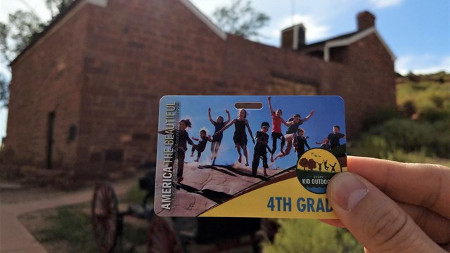 image of 3 fourth graders holding their every kid outdoors passes