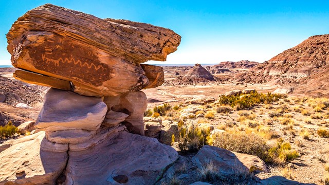 balanced rock with desert landscape in background