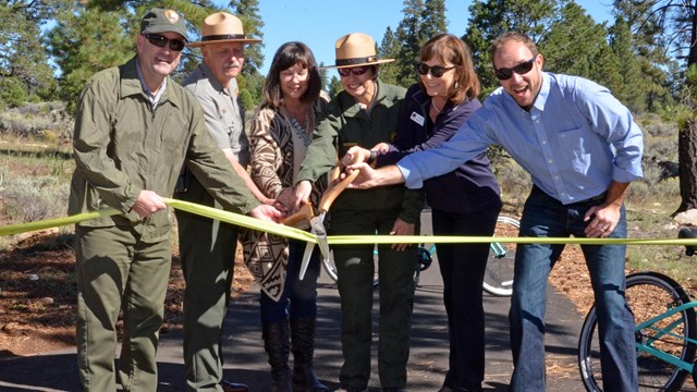 group of people cutting ribbon to signify partnership