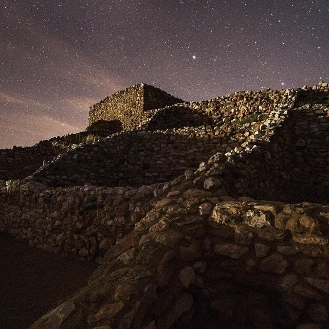 starry night sky illuminating a pueblo