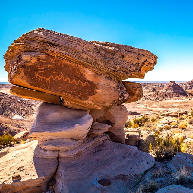 balanced rock with desert landscape in background