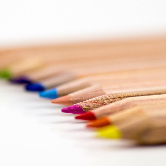 colored pencils lined up on white background