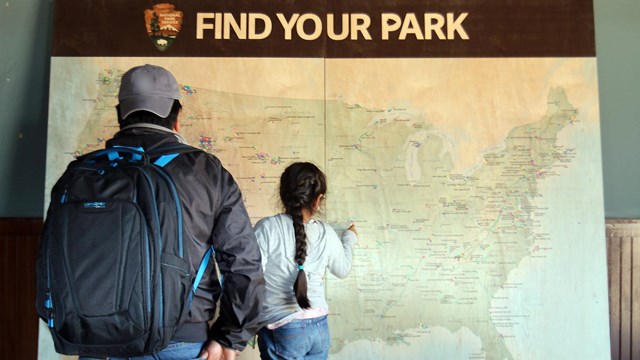 Adult and child looking at a wall map of the U.S.