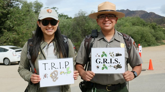 Two rangers holding up instructions 