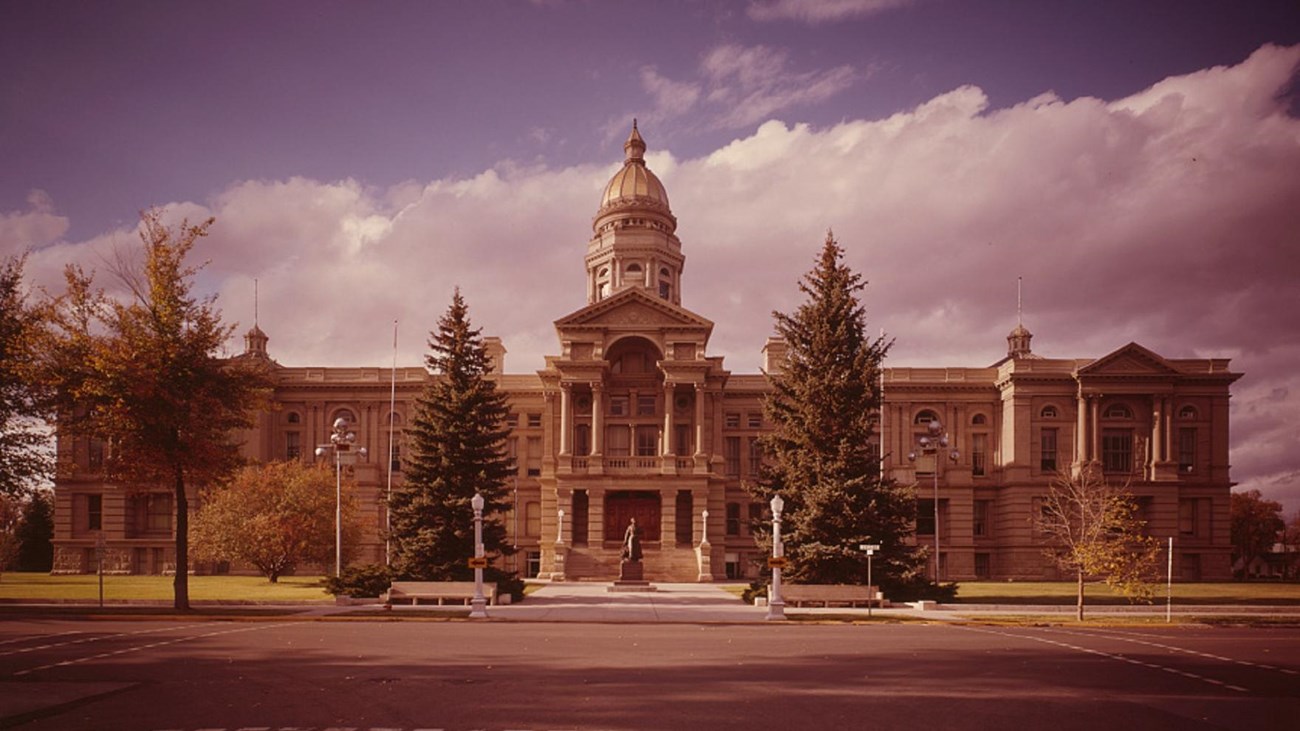 Photo of state capitol building with statue in front. Library of Congress.