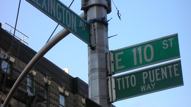 Street pole with 3 green street markers signs. This is on the left side and two others on the right.