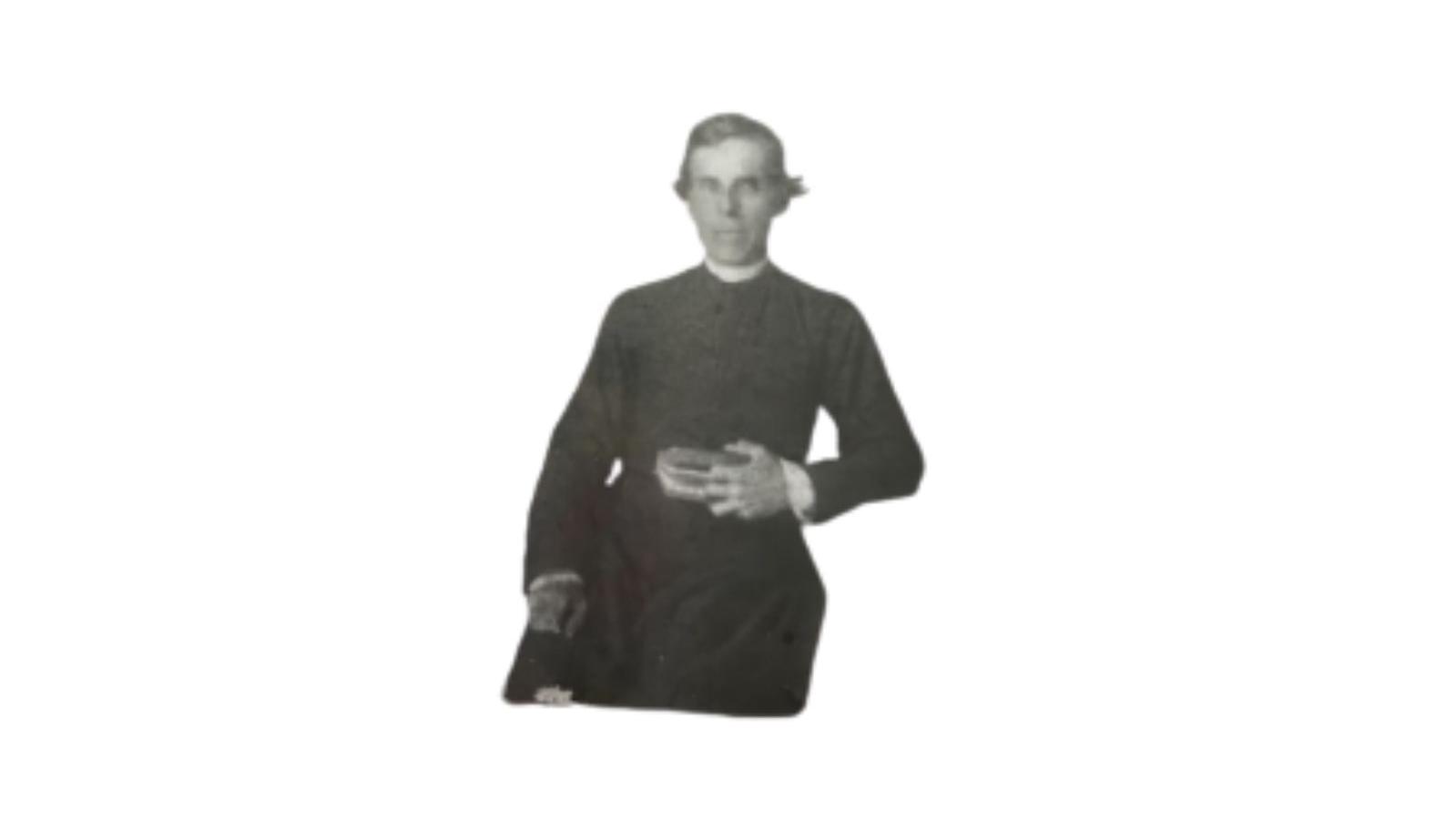 A black and white photo of a man in a catholic father robe holding a book