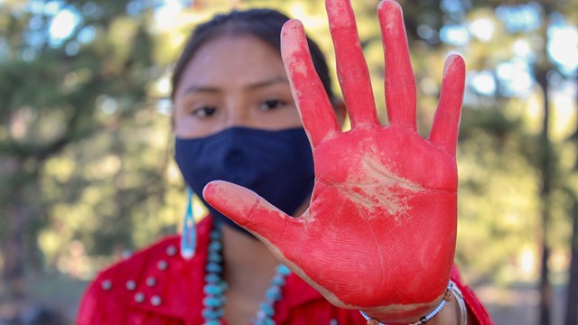 Person holding up a hand painted red