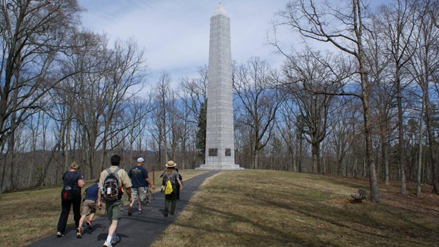 Visitors walk toward battlefield trail
