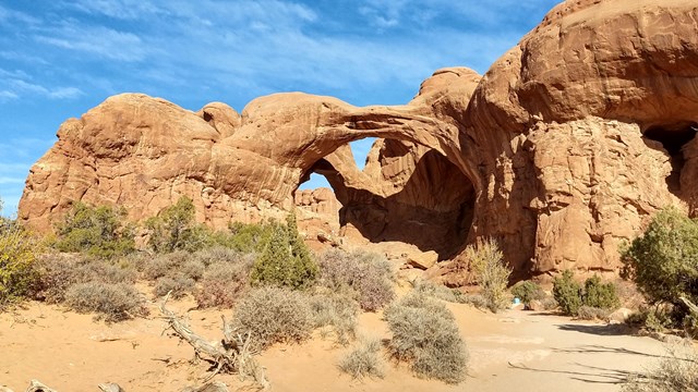 Two large stone arches rise above the Utah desert.