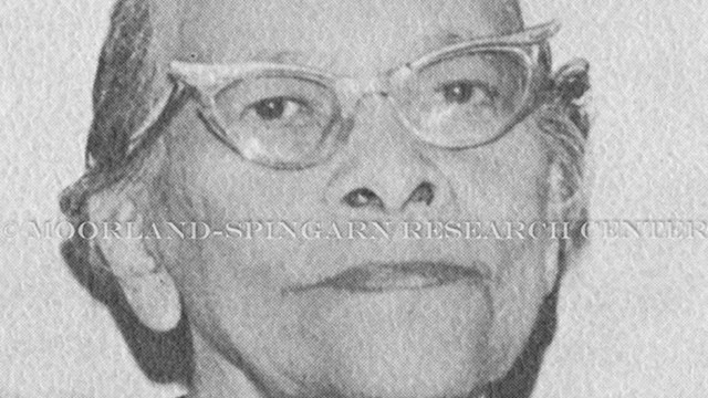 African American woman with hair pulled back wearing cat eye glasses. She appears middle aged.