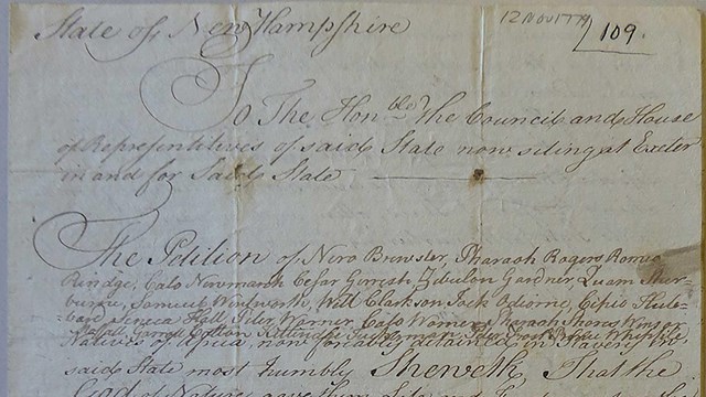 A folded yellowed page full of cursive writing.