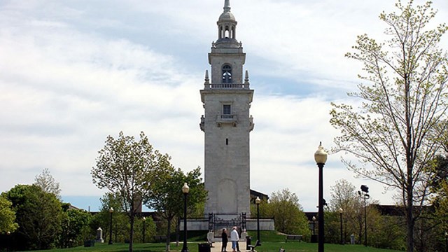 Dorchester Heights Monument with a sidewalk leading up to it and grass on either side.