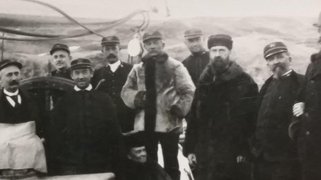 Black and white photo of Captain Michael A. Healy standing with a group of passengers on the deck of