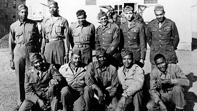 Black and white photo showing Fred Spencer with ten other men in uniform, one row of men is kneeling