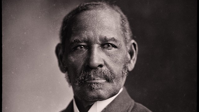 A historical portrait of a man in a suit.