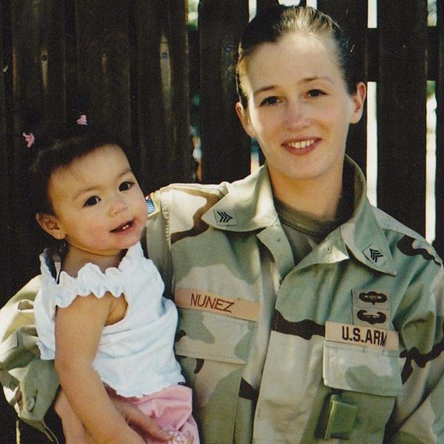 Photo of Jessica in uniform holding a child. Photo courtesy Jessica.