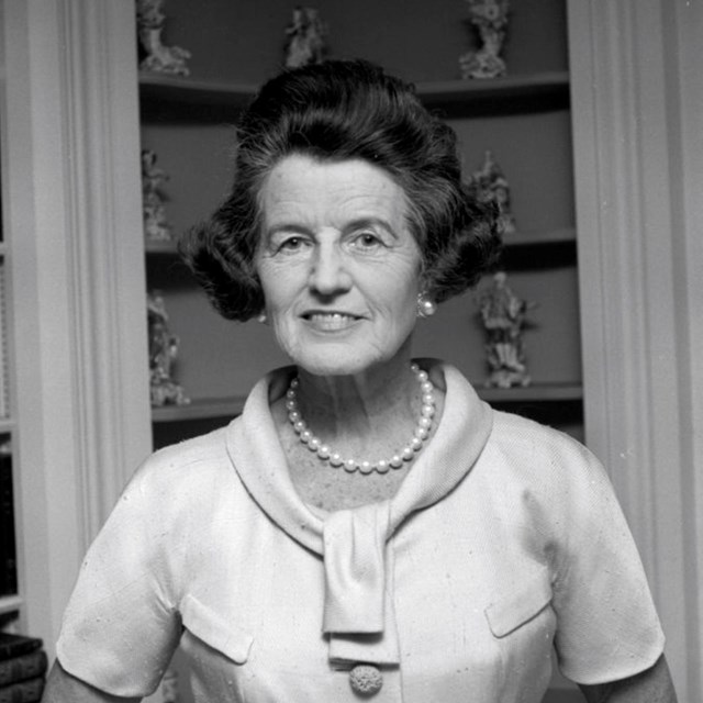 Rose Kennedy poses in front of built-in cabinets 