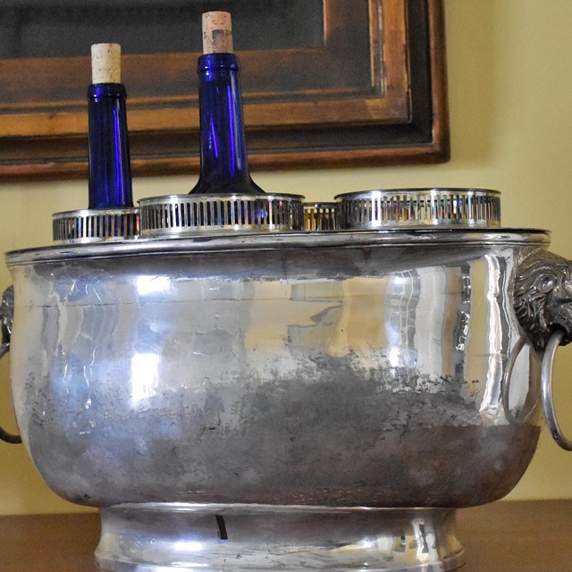 A silver wine cooler with two wine bottles inside. 