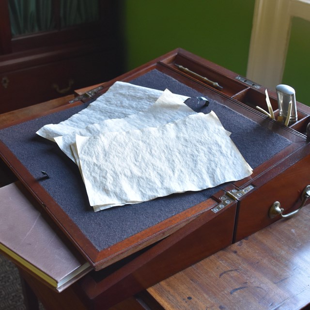 A wooden travel desk sitting on a tea table.