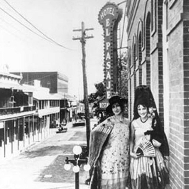 Photo of two women on side of building. 