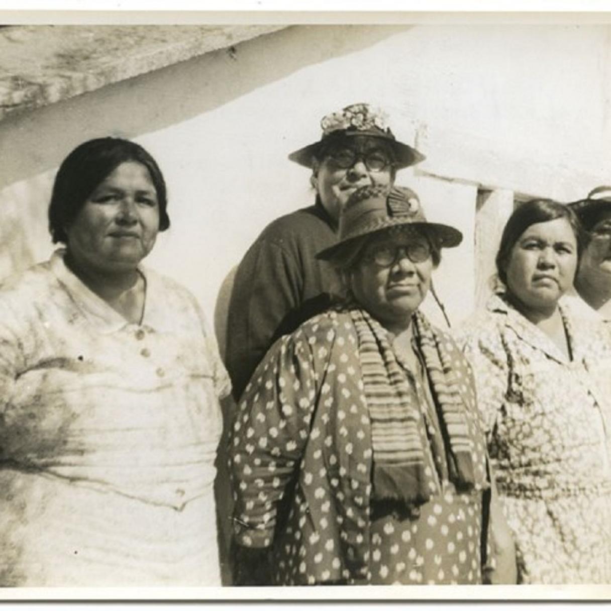 A group of women wearing hats and dresses