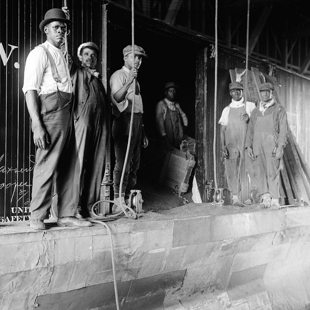 Laborers in front of grain boxcar