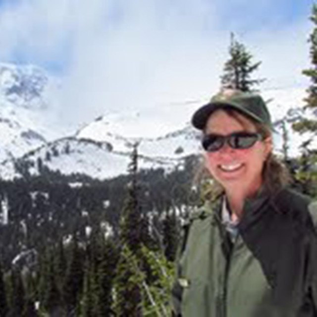 Lisa stands in front of a mountain range