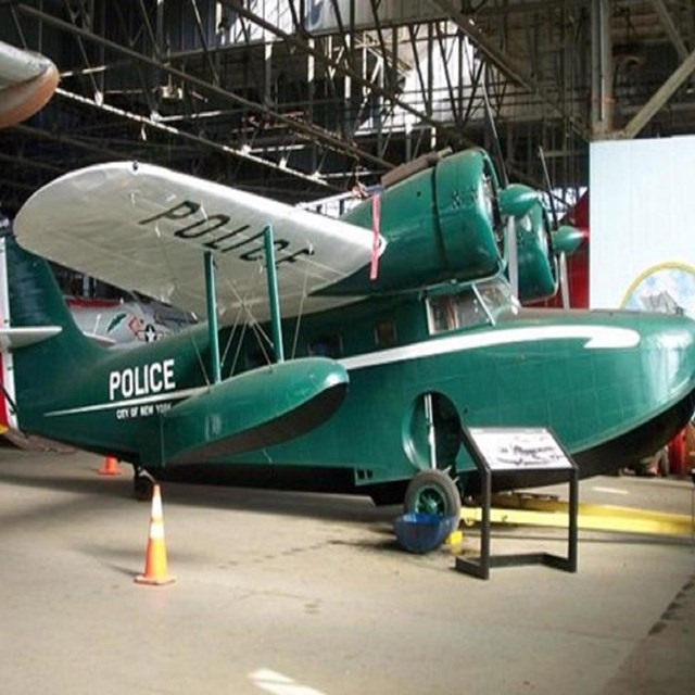 Green police plane in hangar