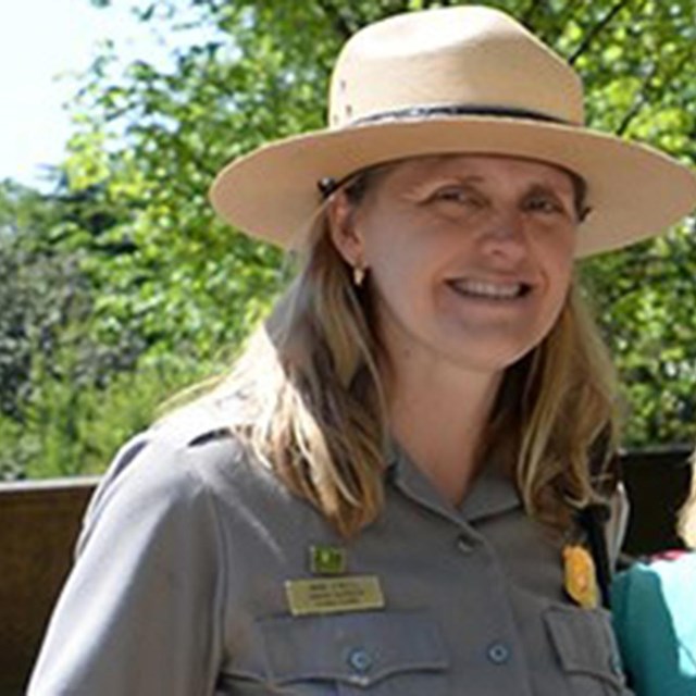 Photo of Anne in uniform against a background of trees