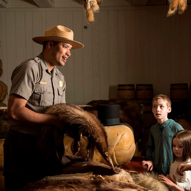 A park ranger talking to kids in the Fur Store at Fort Vancouver.
