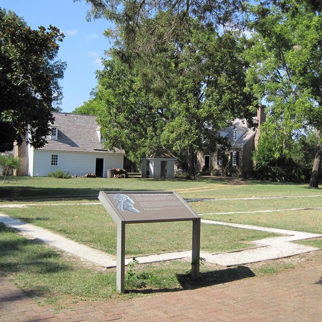 Wayside sign in front of a building foundation outline