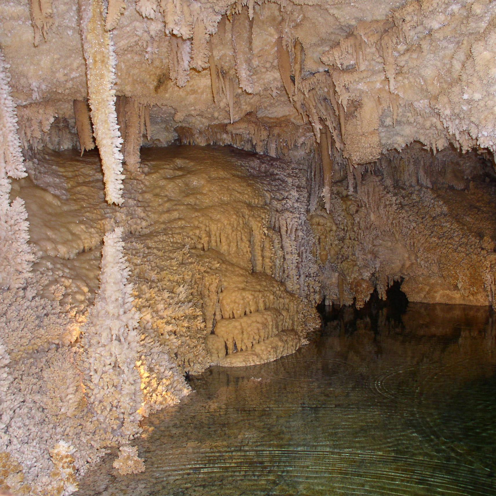 an underground pool and sparkly cave formations in a cave