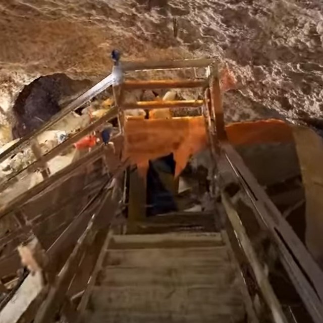 Screencap of animated render of staircase inside underground cavern