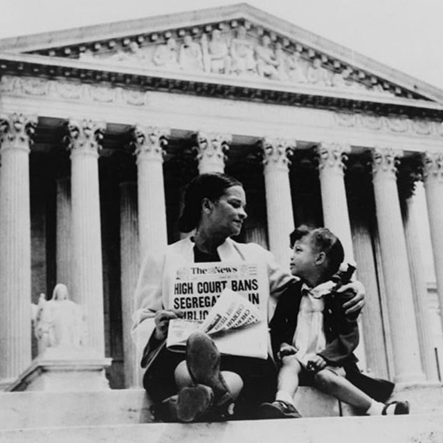 Woman and child sitting on courthouse steps. 