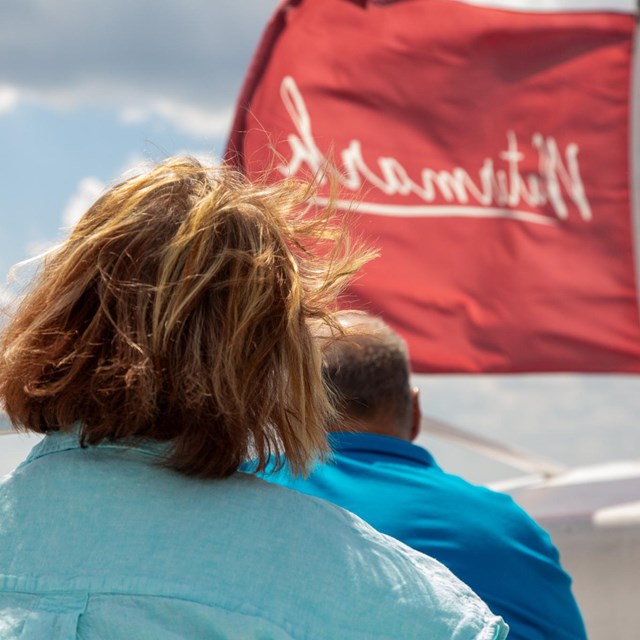 Woman and man on boat with red watermark flag.