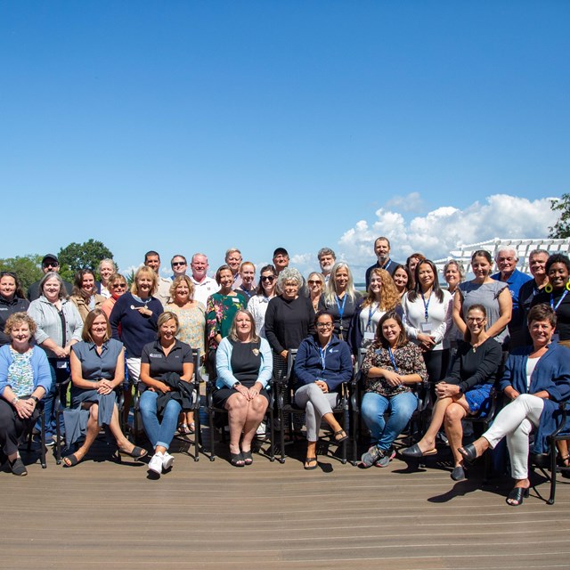 Group photo on patio with water in background.