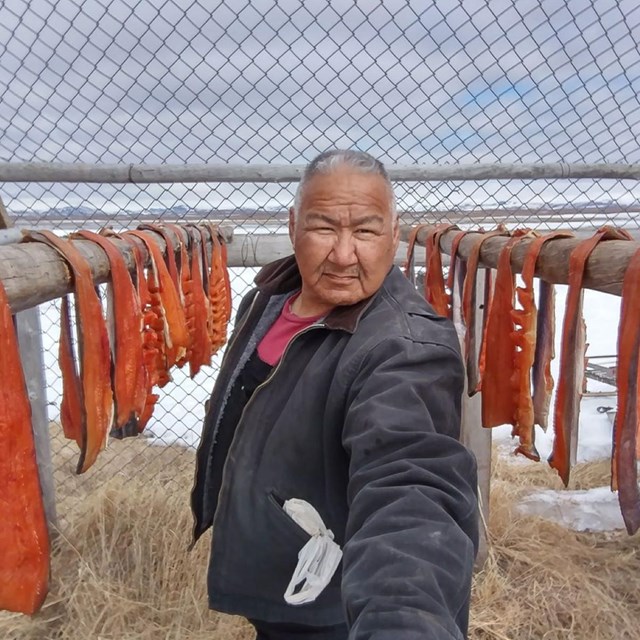 Selfie of a man in front of a fish rack