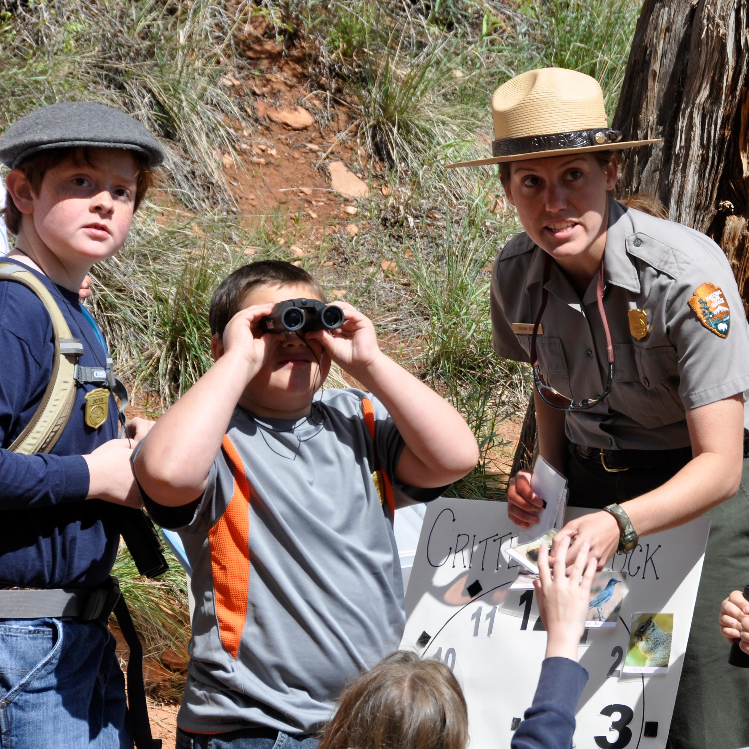 Ranger with kids looking for wildlife