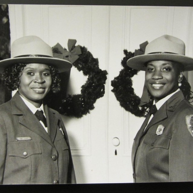 Two African American women smiling wearing NPS uniforms