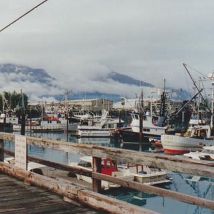 Fishing boats in Valdez Harbor with cloud-covered mountains in the background, 1993