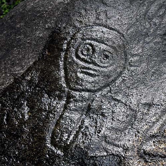 Carved petroglyph in stone of a face