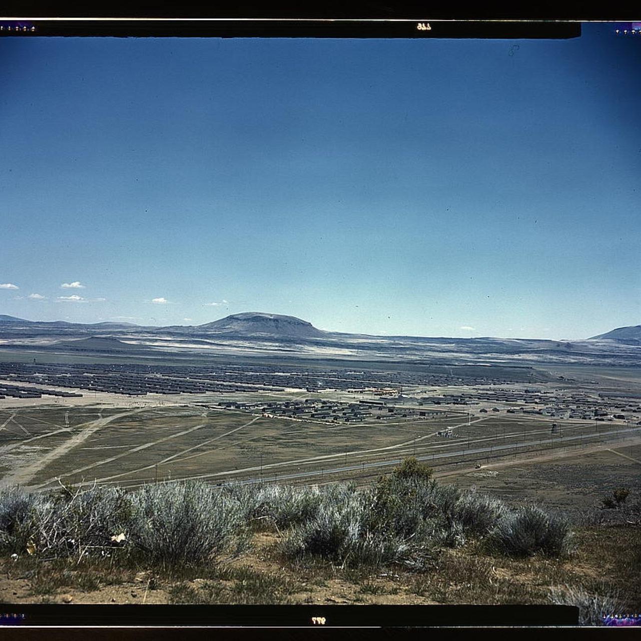 View of a sprawling valley full of orderly buildings with small mountains in the background